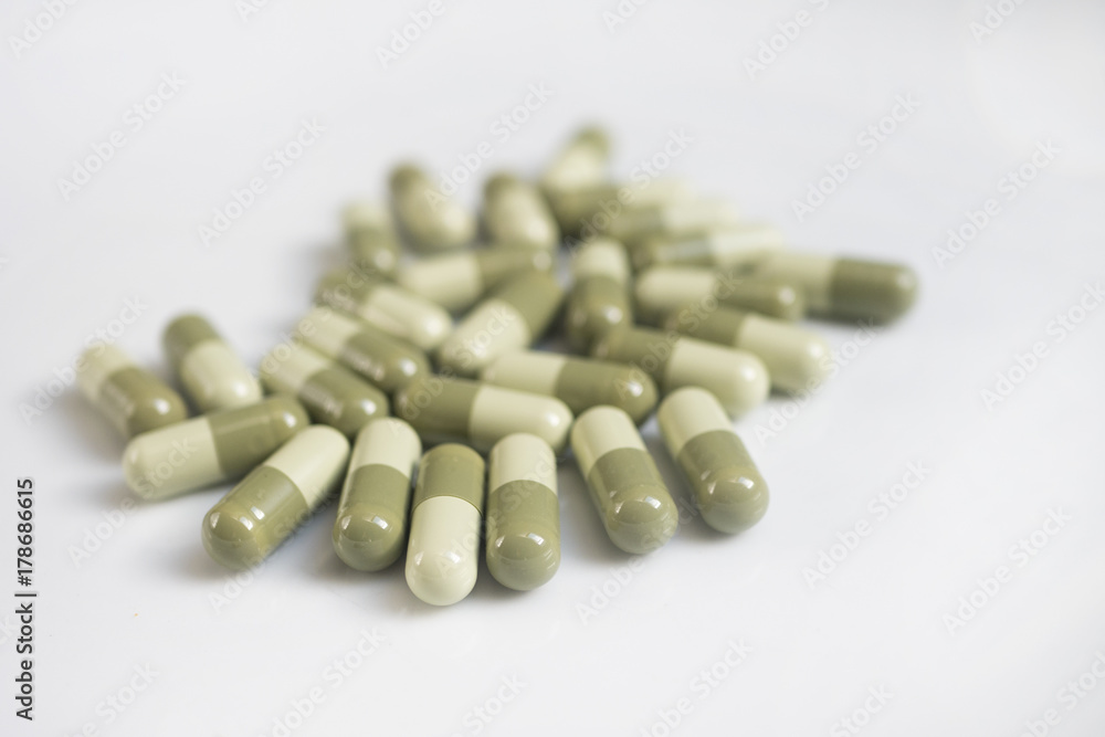 meny green medicine pills on white background meny green medicine pills on white background