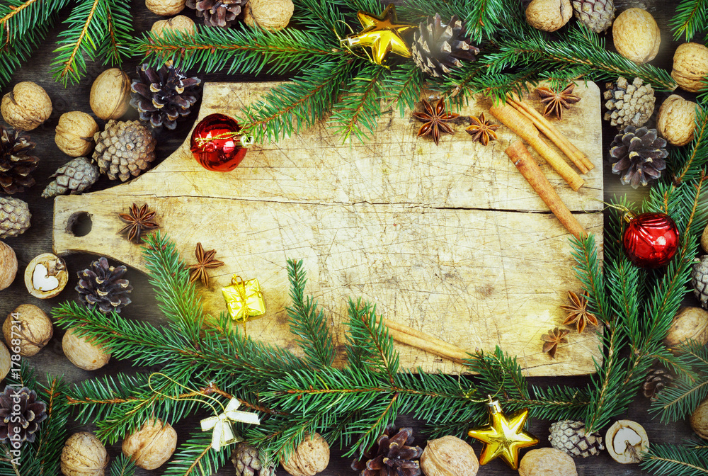 old cutting board with christmas attributes on a wooden kitchen background
