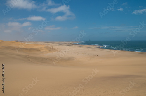 View towards Walvisbay from sand dune near Swakopmund  showing sea edge and oil drill towers