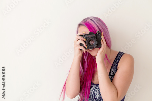 photographer girl with pink hair on a photo shoot with a camera photo