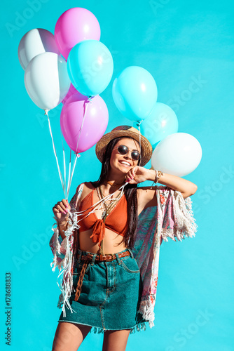 Hippie woman holding colored balloons