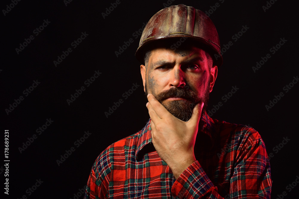 Worker with brutal image wears dirty helmet Worker with brutal image wears dirty helmet