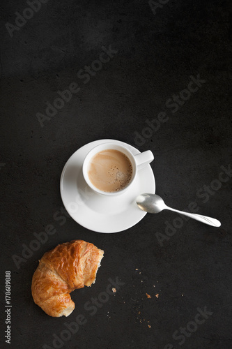 Fototapeta Naklejka Na Ścianę i Meble -  Coffee pot and cup of coffee with croissant on black top view