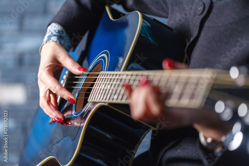 closeup of hands of a musician playing acoustic guitar