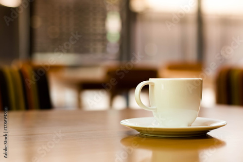 a white cup of tea or coffee on a wooden table in a Cafe close-up with copy space