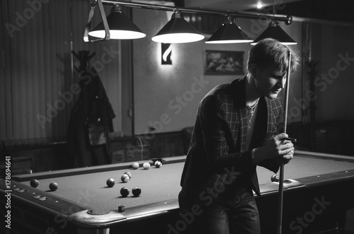 Handsome young man posing with billiard cue