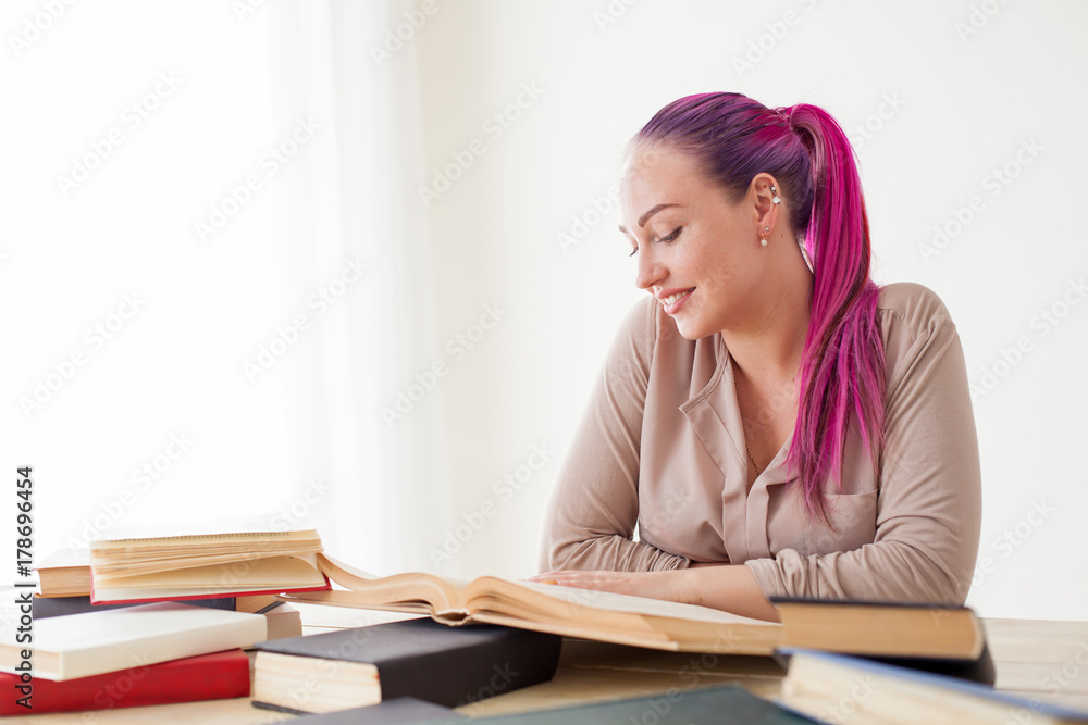 business woman with pink hair sits in the Office reads books education business woman with pink hair sits in the Office reads books education