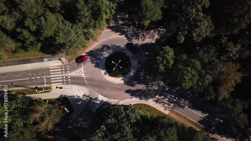 Small roundabout aerial shot. Road in the forest.4k Cars driving photo