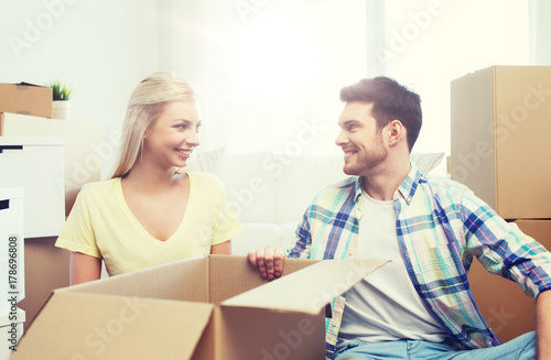 smiling couple with many boxes moving to new home