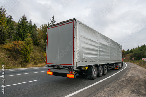 Truck driving on road curve in mountains