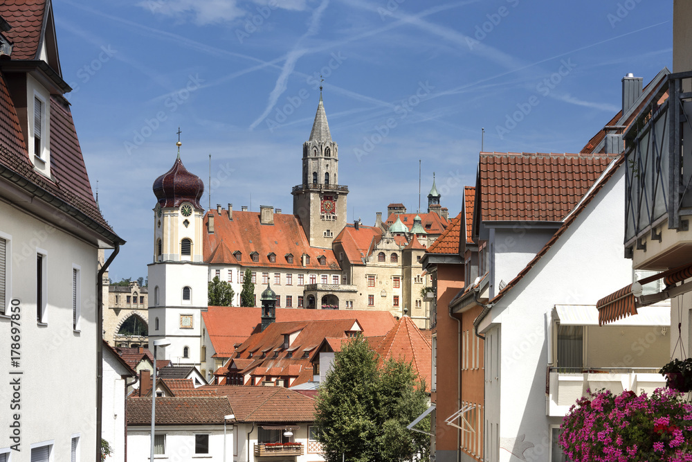 Germany, Sigmaringen, upper Danube: Ancient Hohenzollern castle overlooks old parish church St. John the city with  blue sky in the background.