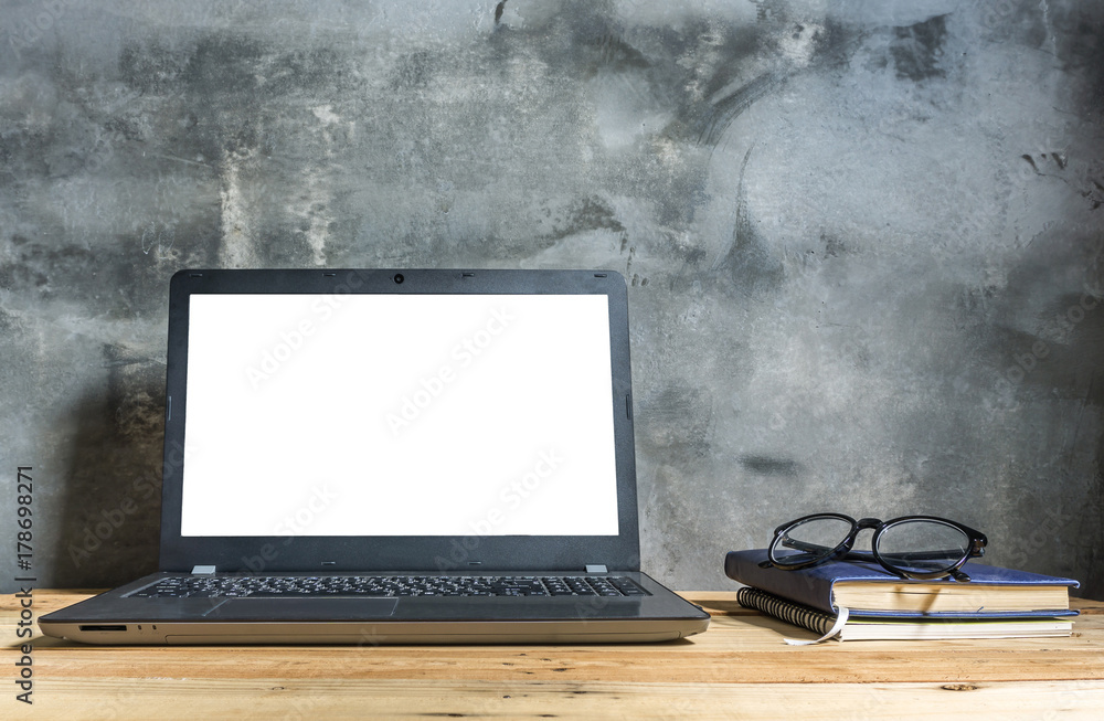 Fototapeta premium wooden table with laptop and stationery on modern loft cement wall background