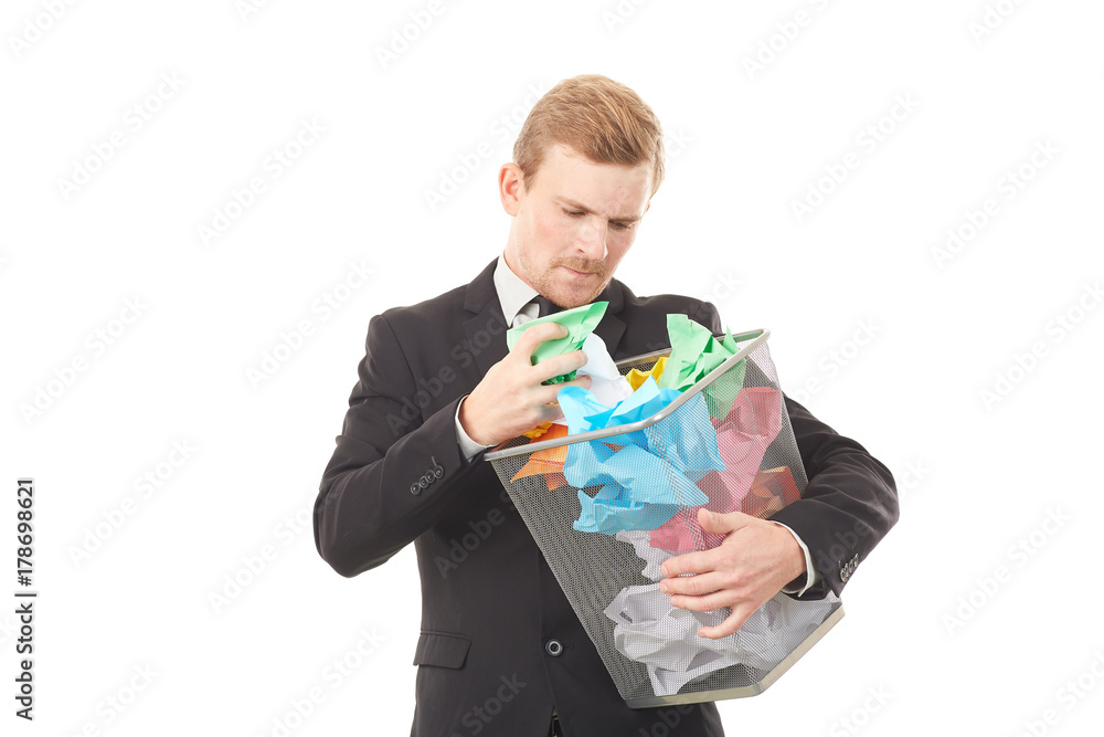 Portrait of businessman searching document in paper basket among crumpled papers Portrait of businessman searching document in paper basket among crumpled papers