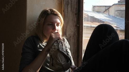 Girl drink alcohol, sitting on on the windowsill. photo