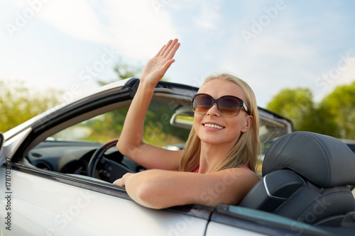 happy young woman in convertible car waving hand © Syda Productions