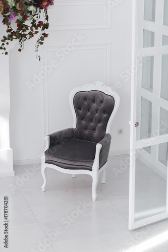 Black and white velours vintage armchair in minimalistic scandinavian room. vertical photo with clear space for text