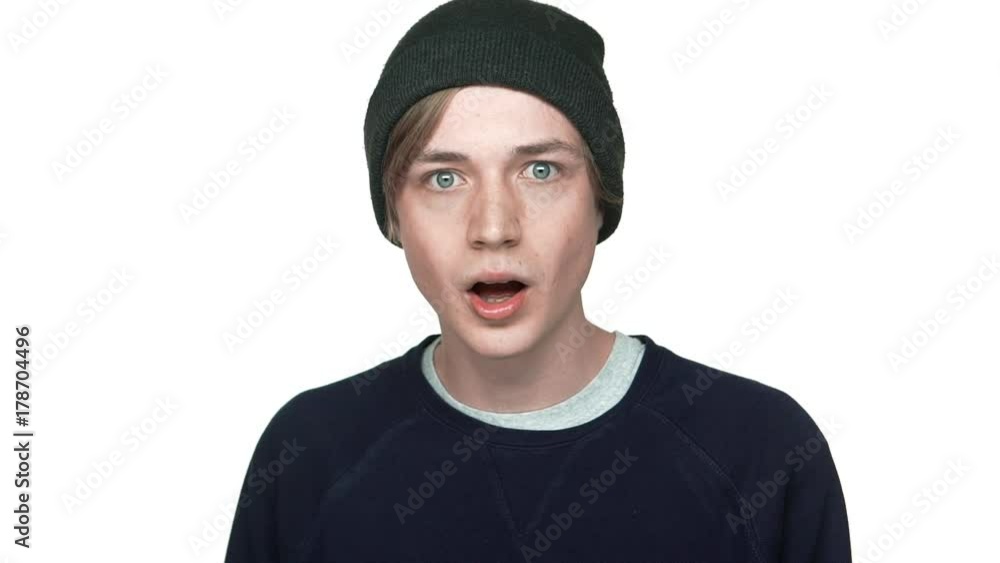 in slow motion portrait of blue-eyed astonished teenager with clean skin being surprised shocked with opened mouth over white background closeup. Concept of emotions in slow motion portrait of blue-eyed astonished teenager with clean skin being surprised shocked with opened mouth over white background closeup. Concept of emotions