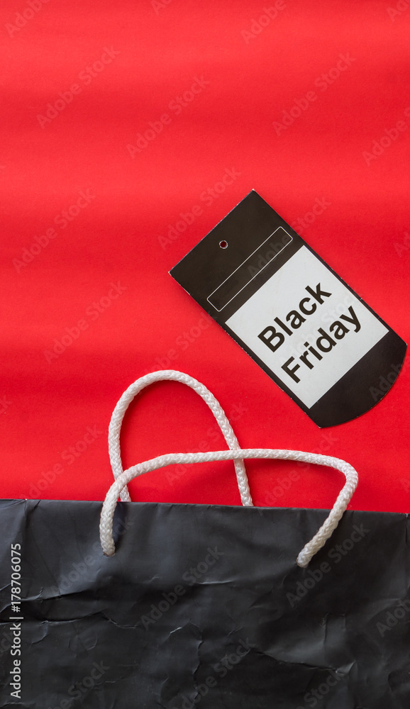 Bสack shopping bag on red background with Black Friday tag, view from above Bสack shopping bag on red background with Black Friday tag, view from above