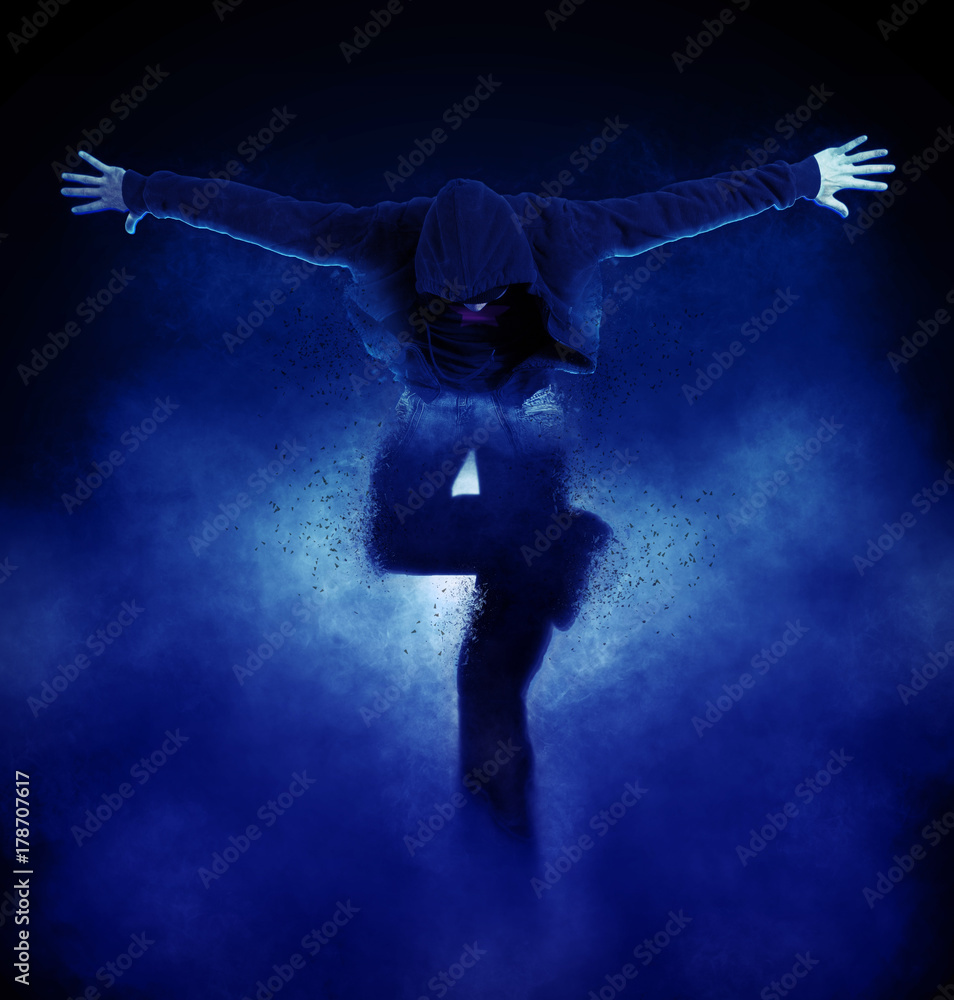 Fototapeta premium Young man break dancing on dark smoke background