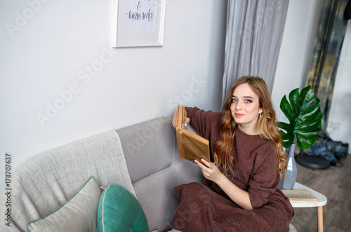Cute lovely young woman reading book on bed