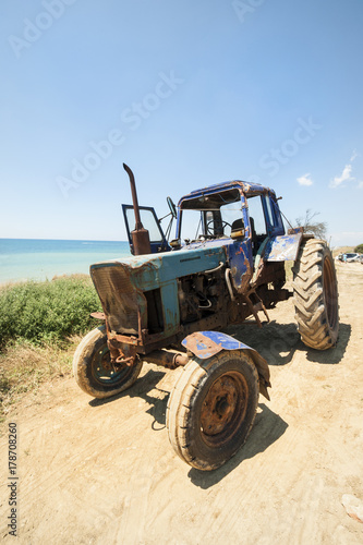 An old tractor standing on the seashore