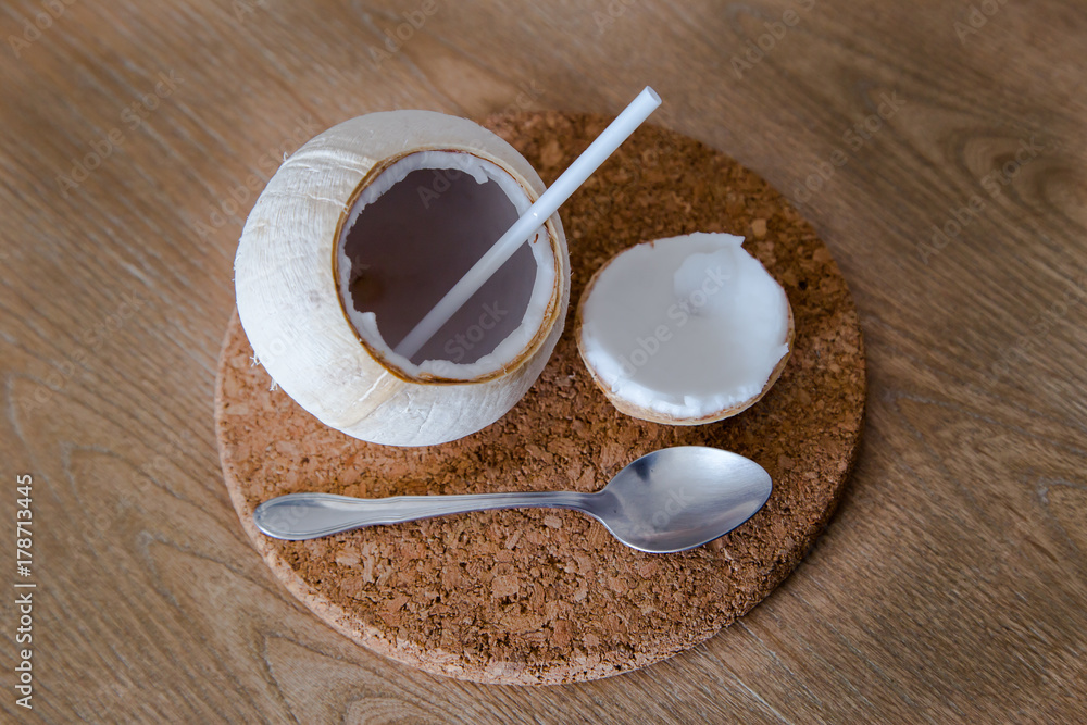 Fresh coconut with straw and spoon on white background Fresh coconut with straw and spoon on white background