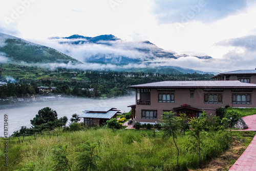 Bhutanese village near the river on a foggy day at Punakha, Bhutan