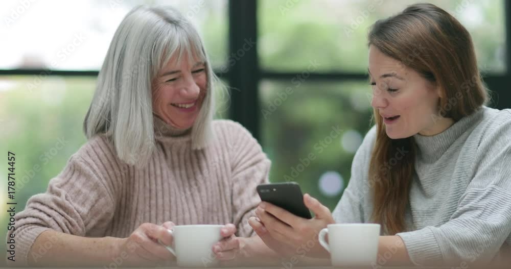 Senior woman and daughter looking at a smartphone Senior woman and daughter looking at a smartphone