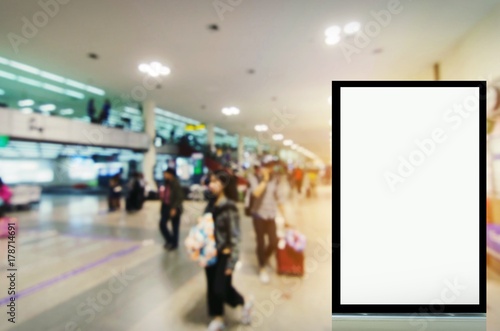mock up of vertical advertising billboard or blank showcase light box for your text message or media content with passenger in terminal at airport, commercial, marketing and advertisement concept