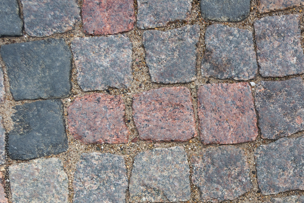 cobblestone pavement. Texture of cobblestone road close-up. Part of the road paved with red black granite. cobblestone pavement. Texture of cobblestone road close-up. Part of the road paved with red black granite.