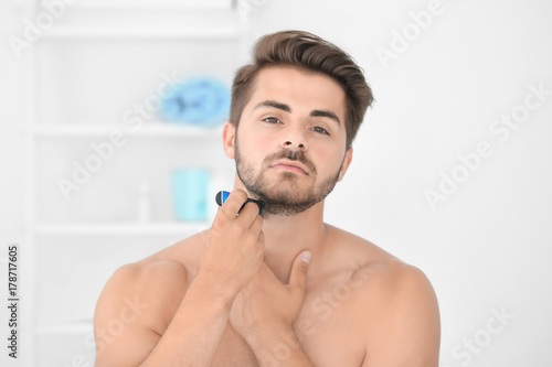 Handsome young man shaving ...