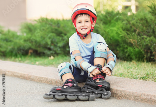 Little boy on roller skates in summer park