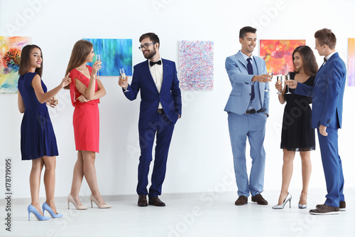 Group of people in formal wear at art gallery exhibition