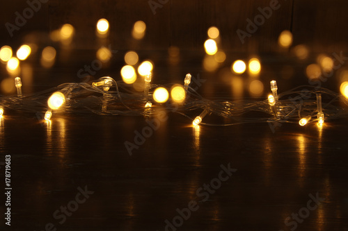 Christmas warm gold garland lights on balck wooden background