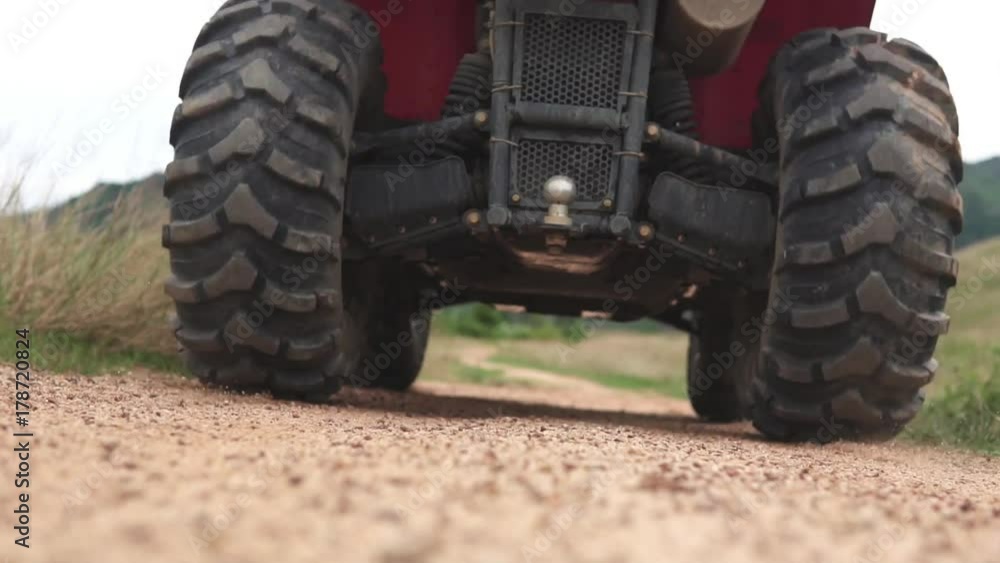 Camera seting under the passing ATV, between the wheels on the dirty road Camera seting under the passing ATV, between the wheels on the dirty road