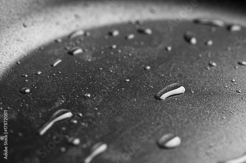 Drops of oil in a teflon frying pan close up.