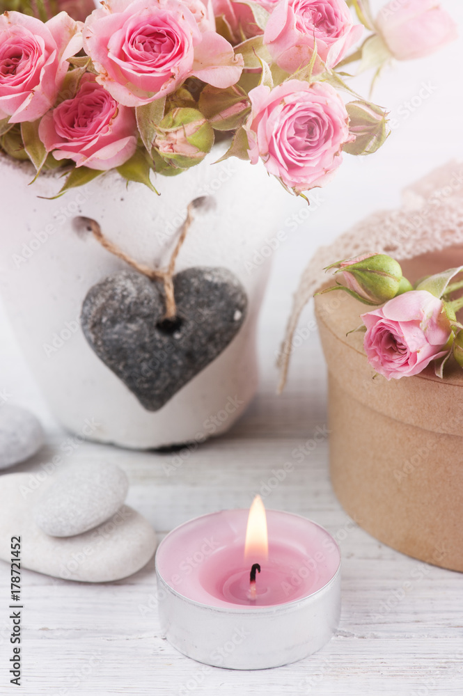 Pink roses in concrete pot with candle Pink roses in concrete pot with candle