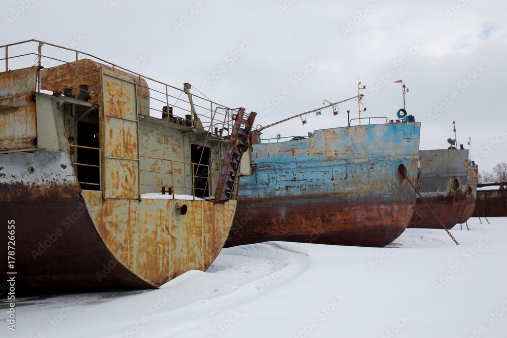 large rusty barges in winter backwater