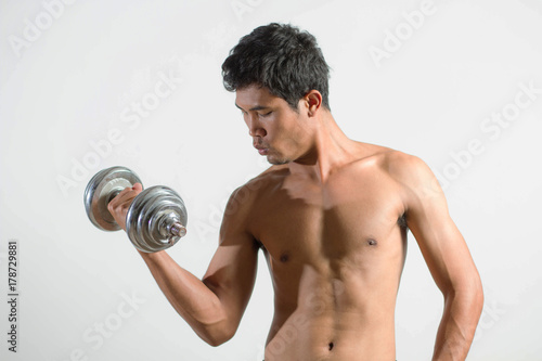 Young man strong fitness with dumbbells on white 