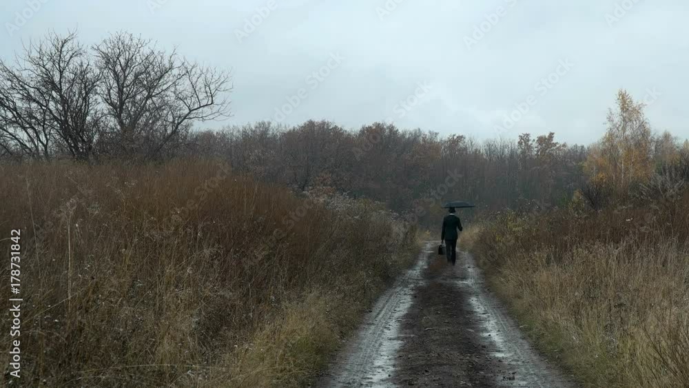man with umbrella walks in autumn forest man with umbrella walks in autumn forest