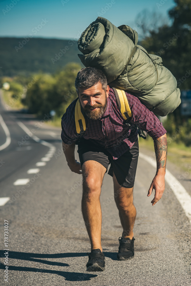 Man hiker happy bend under backpack on asphalt road Man hiker happy bend under backpack on asphalt road
