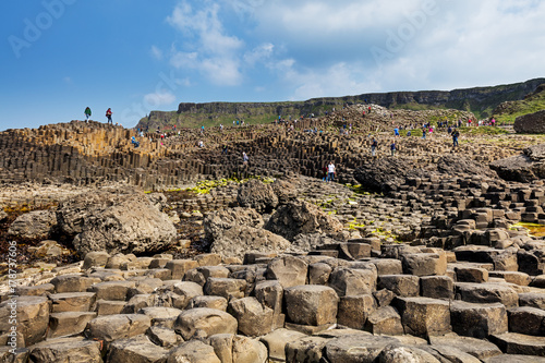 Thousands of tourists visiting Giant's Causeway in County Antrim of Northern Ireland, a World Heritage Site by UNESCO containing about 40000 interlocking basalt columns from ancient volcanic eruption