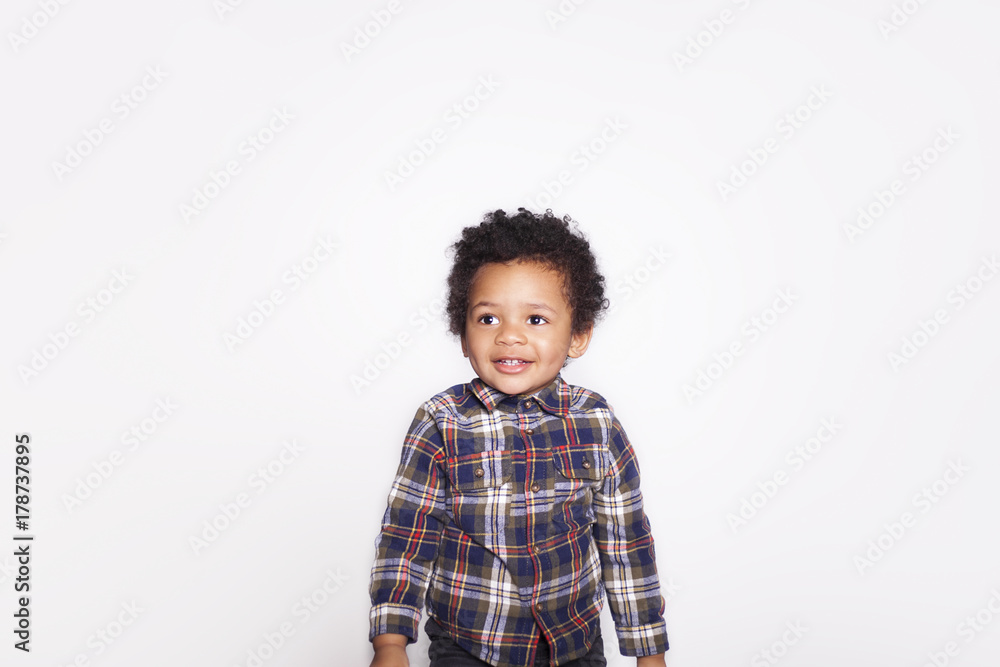 Portrait of a cute smiling african american little boy in checkered shirt isolated on white background. Portrait of a cute smiling african american little boy in checkered shirt isolated on white background.