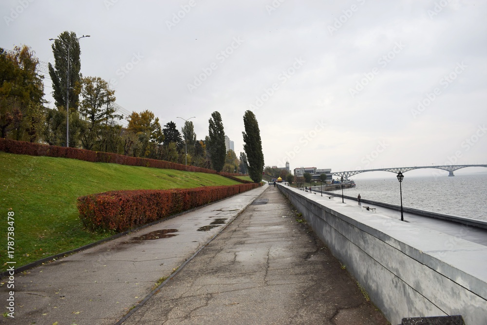 empty embankment of the river and bridge in the distance in autumn