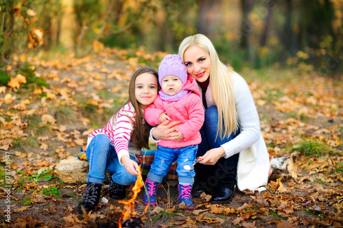 happy family outdoors in a beautiful park, fry marshmallow on fire.