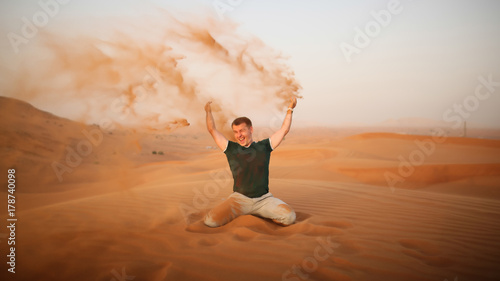Photography The guy throws sand over himself in the desert
