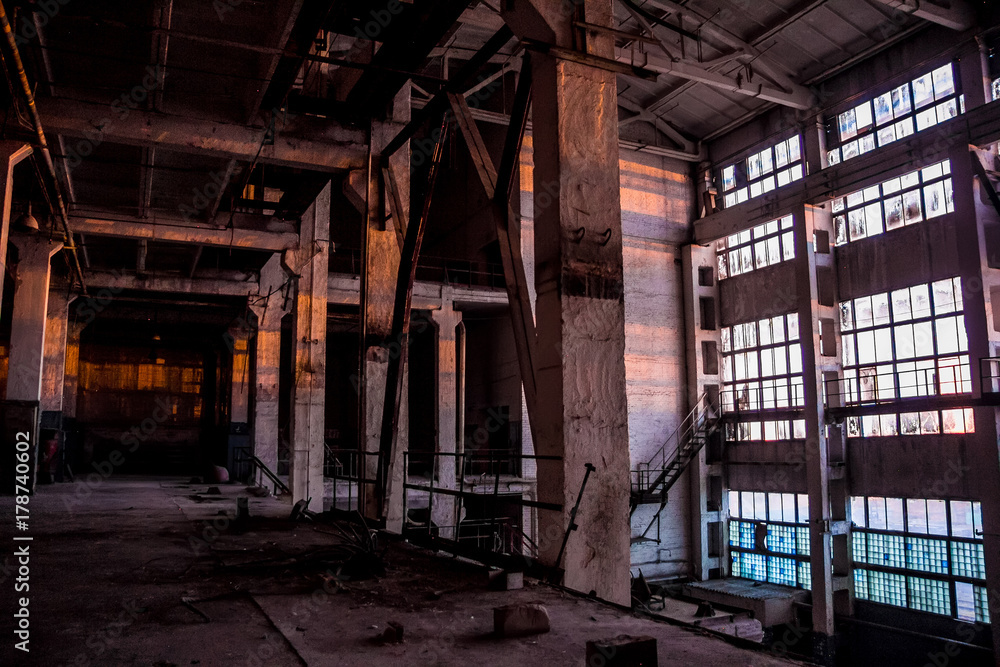 Dark industrial interior of large empty hall for manufacturing or warehousing. Abandoned factory
