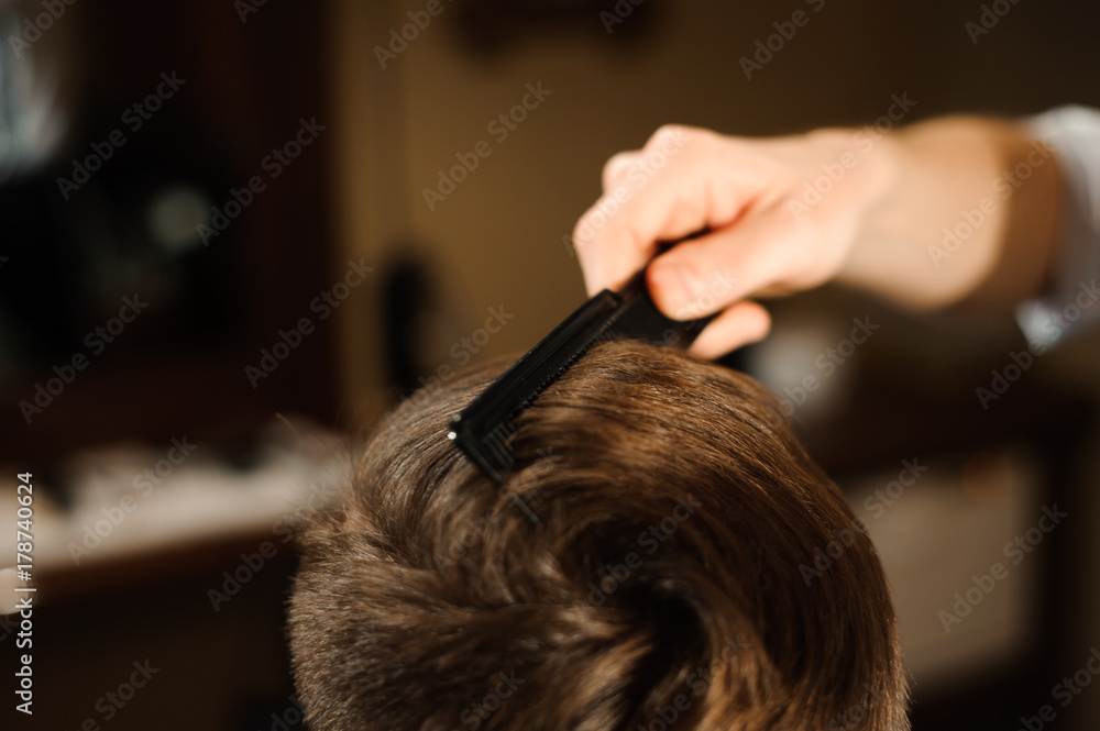 Master cuts hair and beard of men in the barbershop Master cuts hair and beard of men in the barbershop