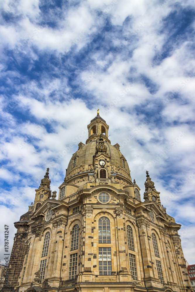 Famous Church Frauenkirche in Dresden against a blue sky with white clouds. Fragment. Saxony, Germany