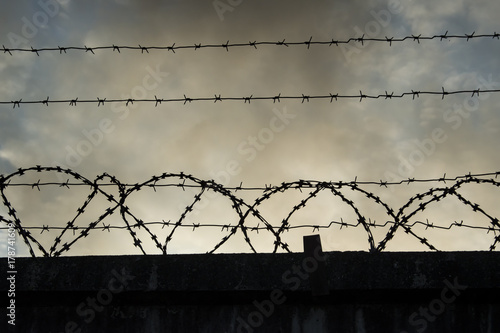 Barbed wire on dark fence. photo